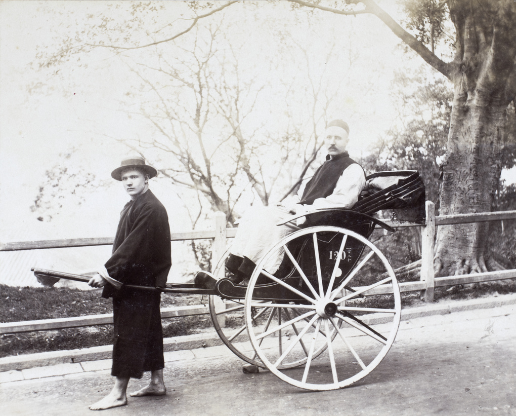 Two European men dressed in Chinese clothing as rickshaw man and passenger