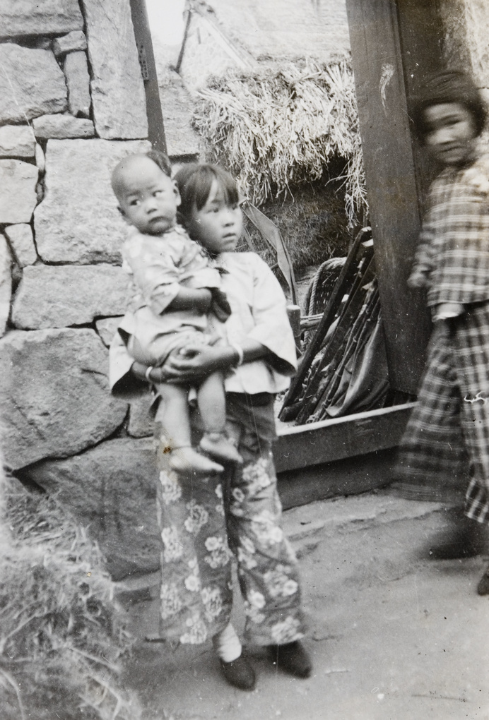 Three children beside a door frame