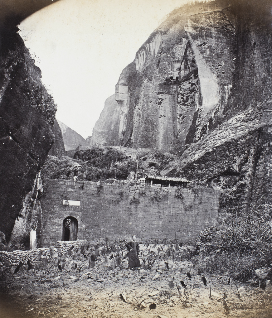 Three men standing at the front of Chiek Sung Grotto, near Xingcun, Fujian