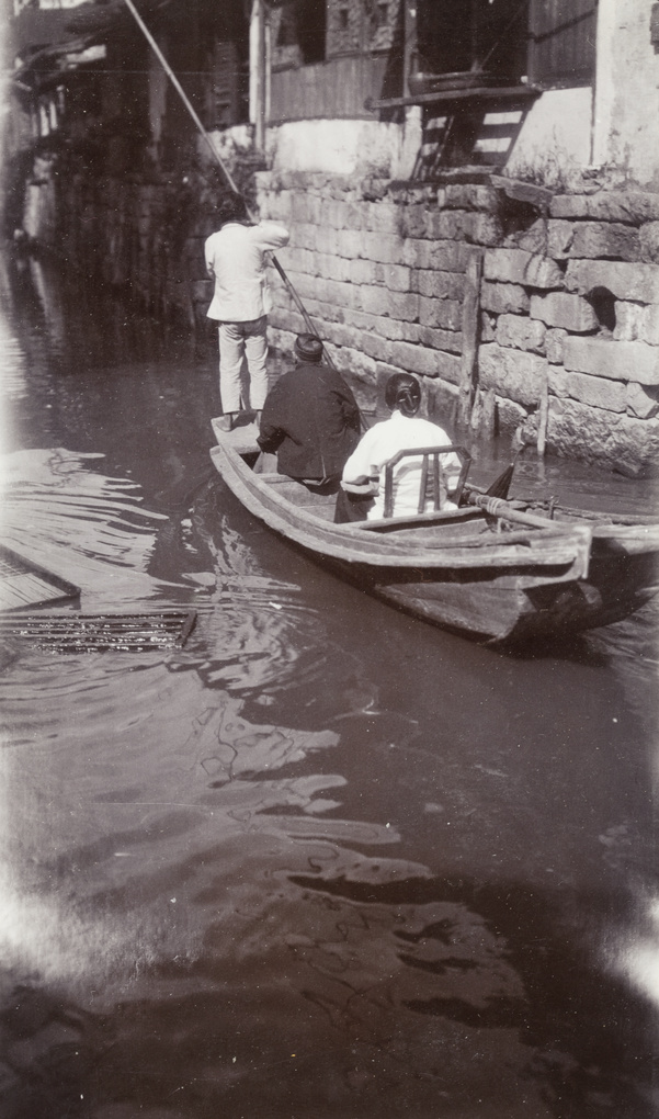Punting passengers on a canal in a town or village 