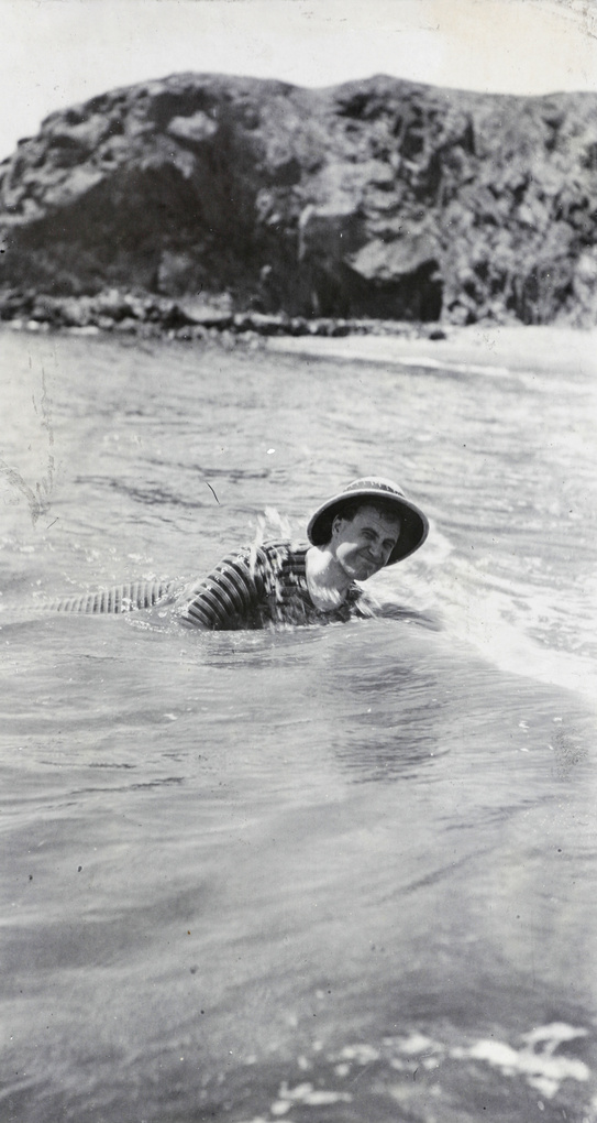 Reginald Hedgeland swimming at Qinhuangdao, wearing a pith helmet