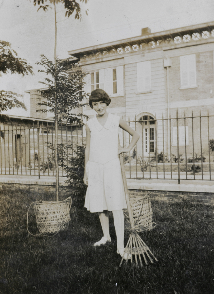 A woman in a garden with rake and baskets, Swatow