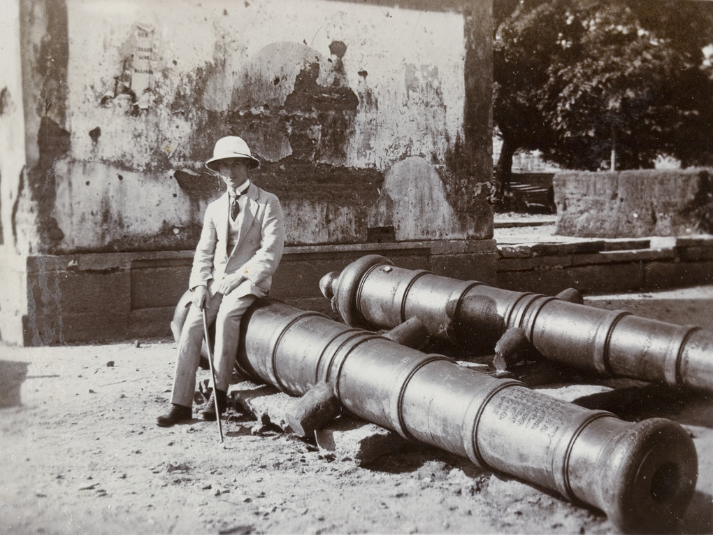 Mac beside cannon, from old Chinese fort, Kowloon, Hong Kong