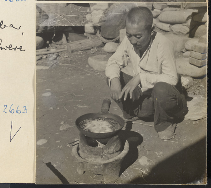 Head guide cooking outdoors on a portable clay stove in the Lost Tribe country