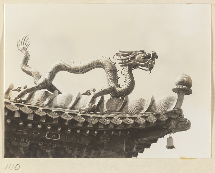 Detail showing double-eaved roof of Miao gao zhuang yan dian with a dragon and a bell