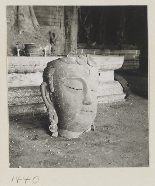Head of a Bodhisattva set on the ground in front of an altar at Da Fo si