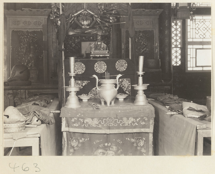 Altar with ritual objects, multi-armed statue, and musical instruments including mu yu at Fa yuan si