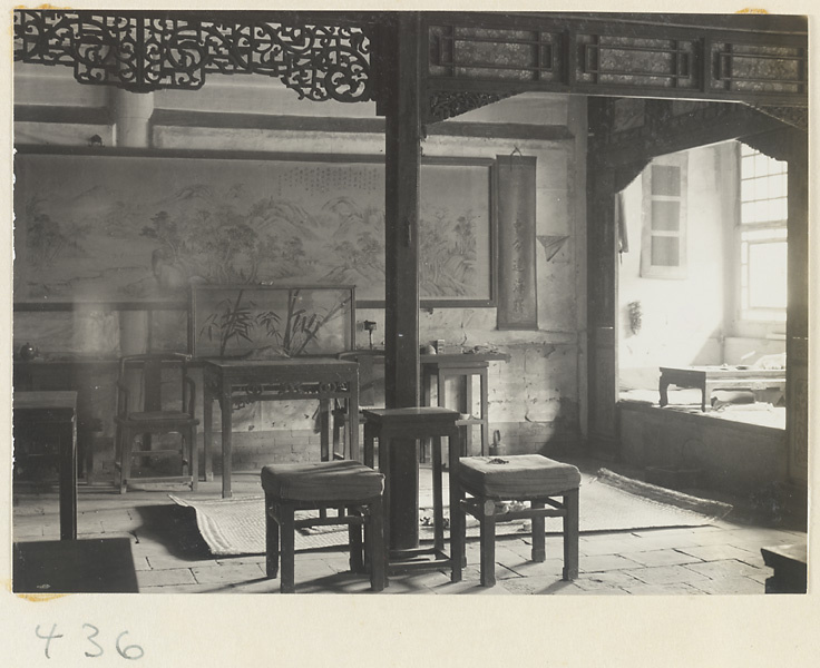Interior of temple building showing room with furniture, hanging scrolls, horizontal scroll painting with inscription, latticework, and carpet at Bai yun guan