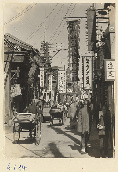 Street scene showing rickshaw pullers and shop signs for a noodle shop (left), restaurants (center bottom), and a cigarette shop (center top)