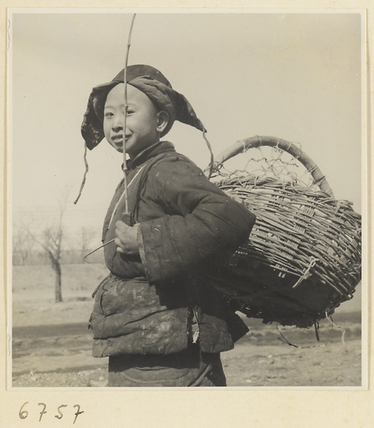 Boy with basket collecting waste paper
