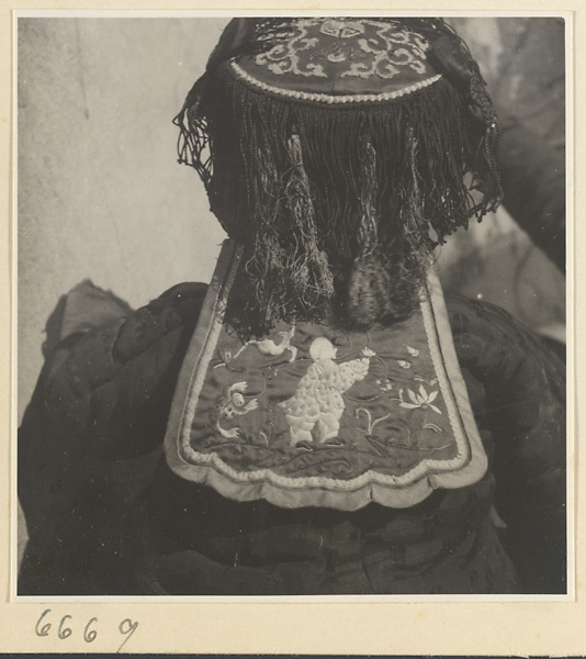 Child wearing a fringed hat with embroidery
