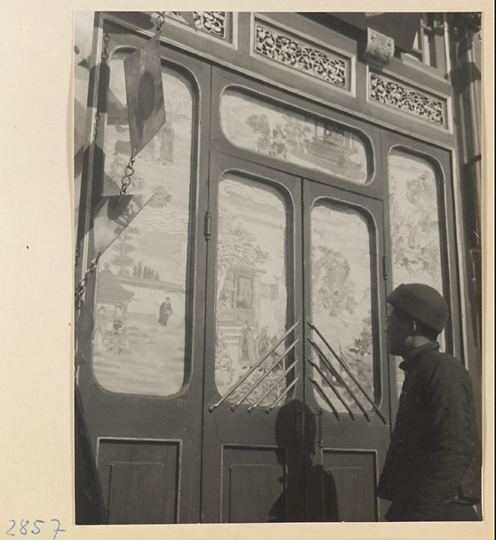Shop front with New Year's scenes painted on paper windows and shop sign for a pharmacy (left)