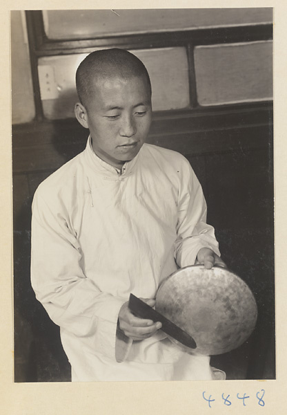 Musician playing a tang luo to accompany a shadow-puppet performance