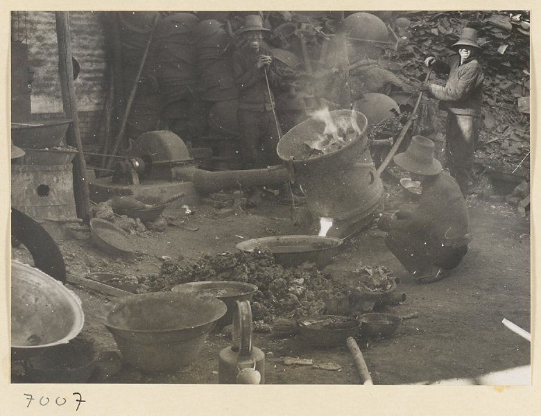 Men working at a forge at a foundry near Mentougou Qu