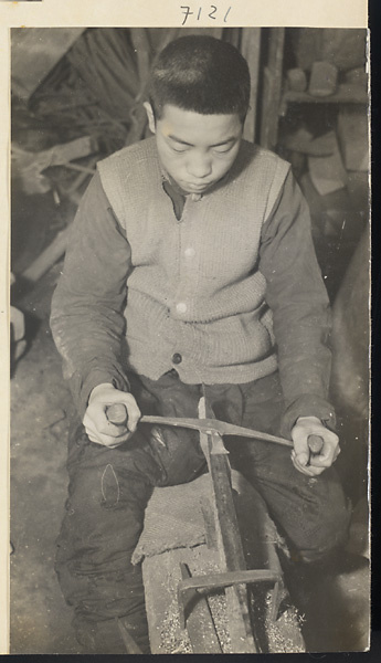 Blacksmith's assistant at work in a shop