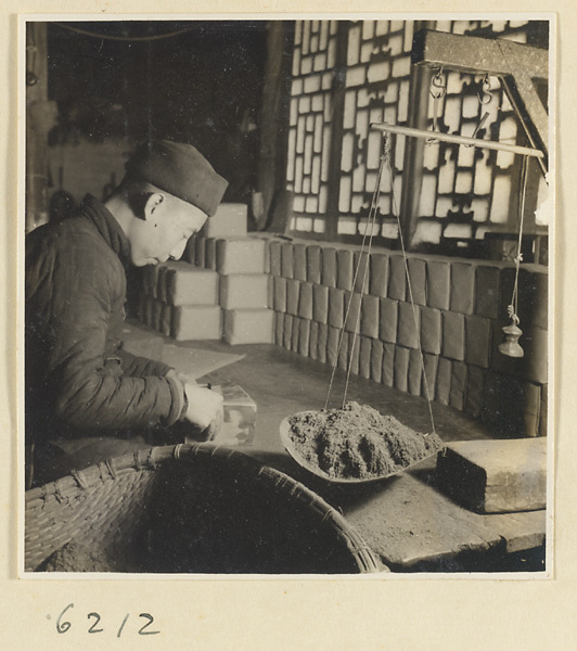 Tobacco shop interior showing a man weighing and packing tobacco