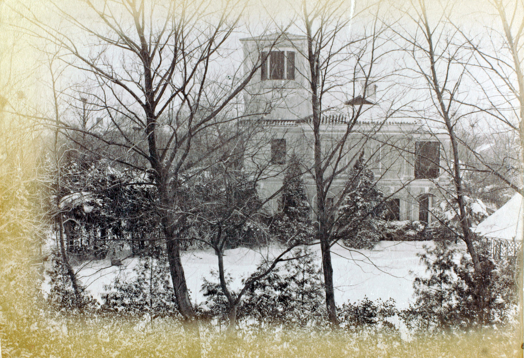 Grand house viewed through wintry trees