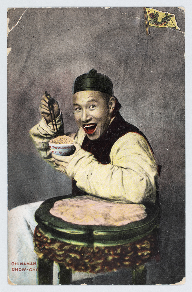 A smiling man posed eating, in a photographer's studio