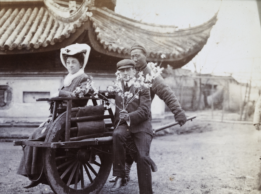 Peggy Kirton and Leo Dudeney on a wheelbarrow, with blossom, Longhua Pagoda, Shanghai