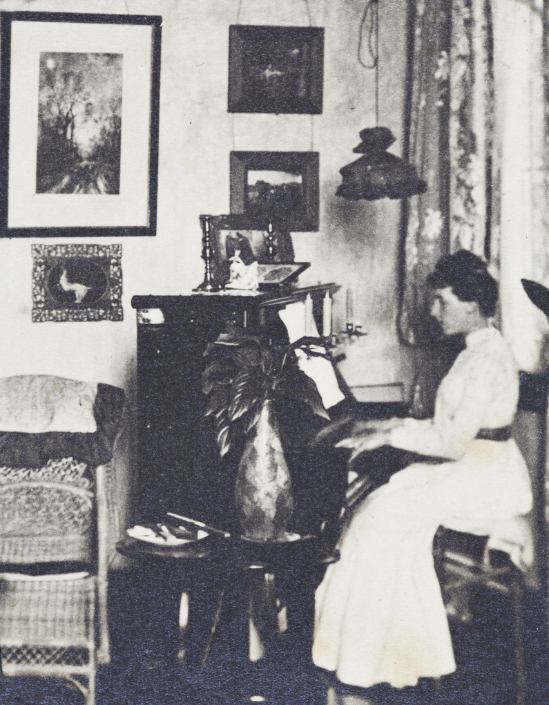 Nellie Dudeney playing the piano in the Kalee boarding house apartment, Shanghai