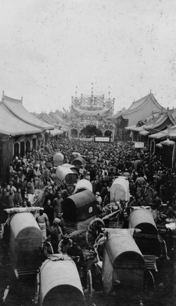 Crowd and carriages near a street theatre stage