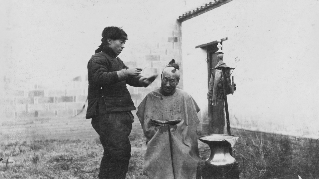 Itinerant street barber, with customer