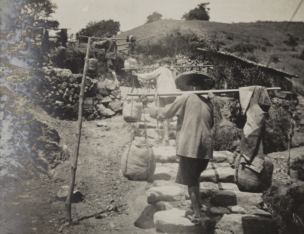 Porters going up a hill pathway, at a mountain pass