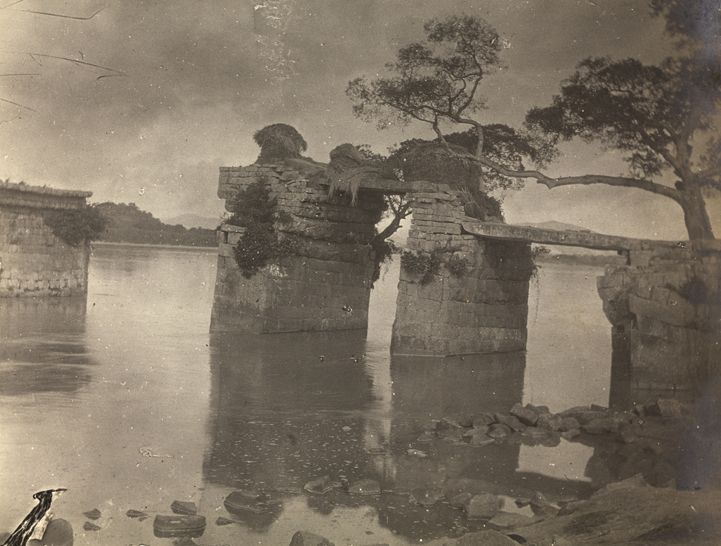 Ruin of a bridge, with thatch/reed stacks, near Qhanzhou