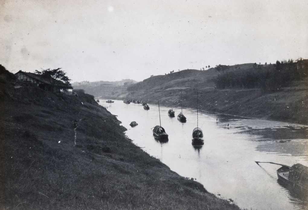 Sampans on a river, with gently sloping banks