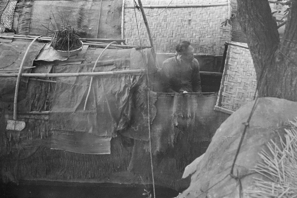 Man in patch-repaired sampan, Shanghai