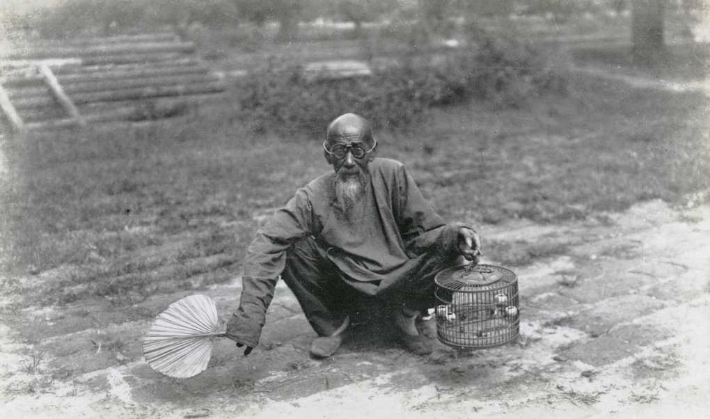 Old man with birdcage and fan
