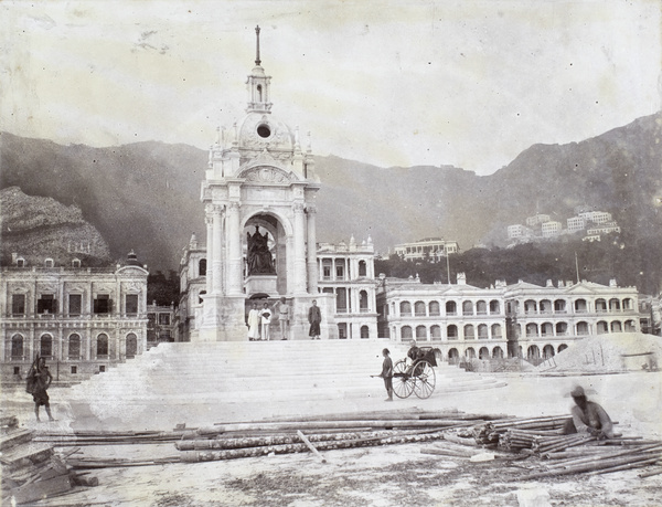 Chinese and a Sikh police standing in front of Queen Victoria's statue, Hong Kong