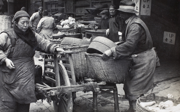 Food market traders with a wheelbarrow and baskets of produce