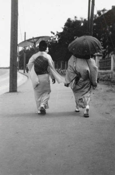 Two Japanese women walking on a pavement