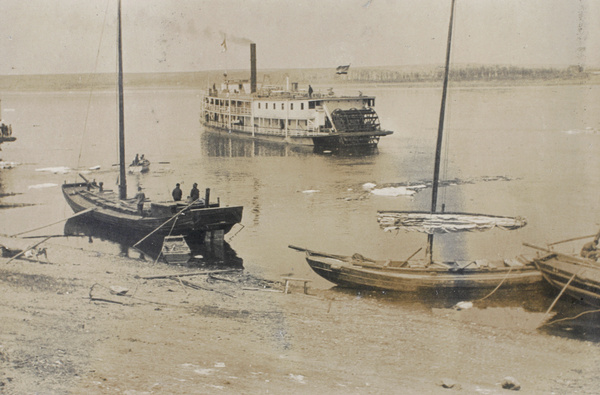 An icy Amur River at Aigun, with paddle steamer and junks