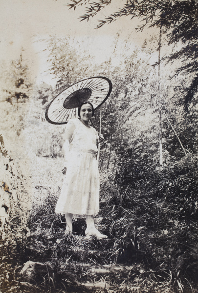 Margie Hutchinson holding a parasol, standing on steep steps, Moganshan