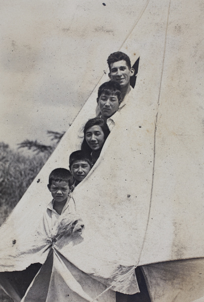 John Henderson, Dick, Maggie and Fred Hutchinson, with an unidentified child and a dog, posing inside the entrance to a canvas bell tent, Shanghai