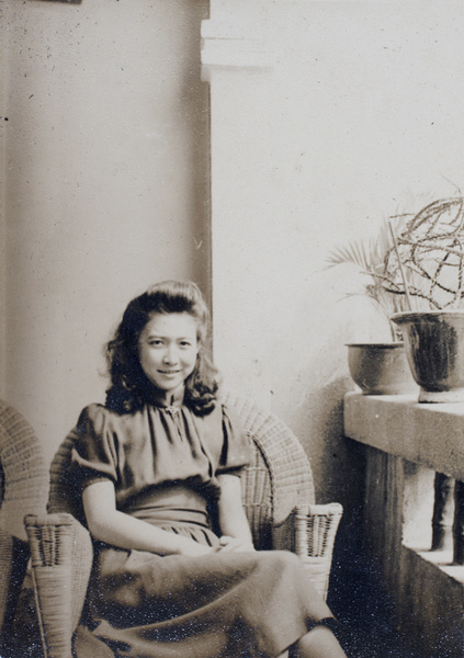 Gladys Hutchinson sitting on the veranda of the apartment block 166-188 Prince Edward Road, Kowloon, Hong Kong