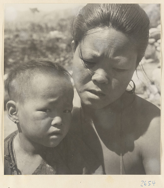 Woman wearing jewelry holding a child in the Lost Tribe country