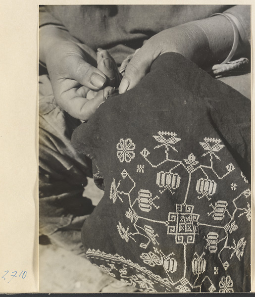 Woman embroidering a cotton apron in Lo-pu-ch'iao Village [sic] in the Jumahe Valley