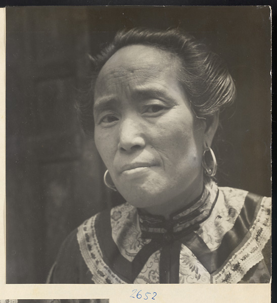 Woman wearing elaborate heirloom robe and earrings in Sang-yuan Village [sic] in the Lost Tribe country