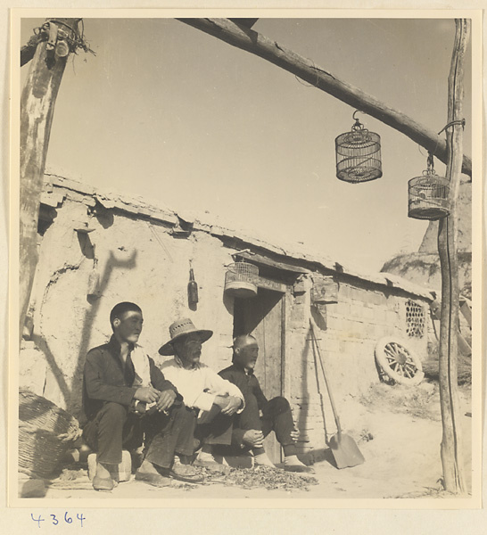 Men sitting next to a building at a brick factory near Baoding