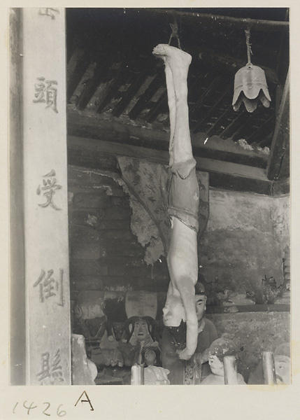Interior view showing inscription, male figure hanging by his feet, and bell at Dong yue miao