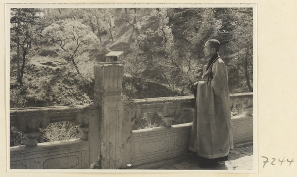Monk standing on a terrace with a marble balustrade at Jie tai si