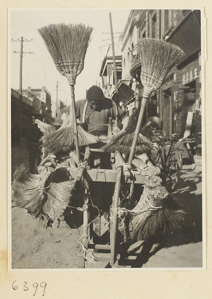 Brush vendor pushing cart with brooms and brushes