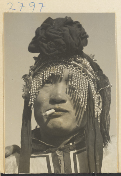 Soldier in costume wearing a beaded headdress and smoking a cigarette at New Year's