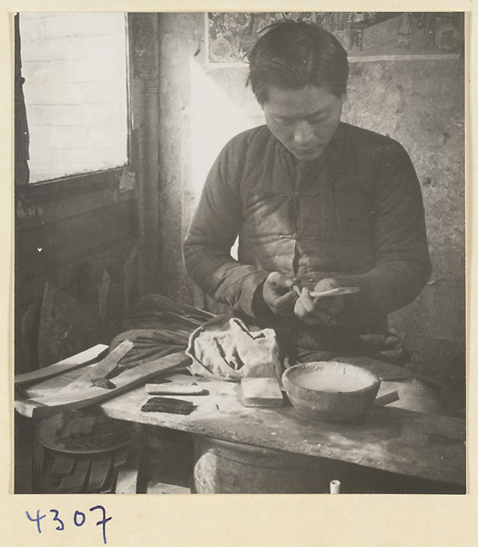 Man at work in a brush-making shop