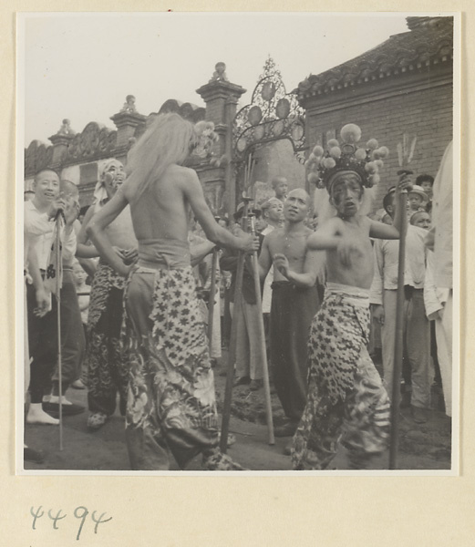 Street entertainers with costumes and headdresses performing in front of a crowd at Tianqiao Market
