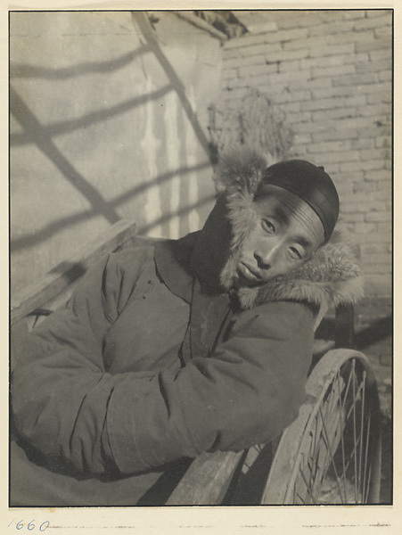 Man dressed in winter coat sitting on a cart