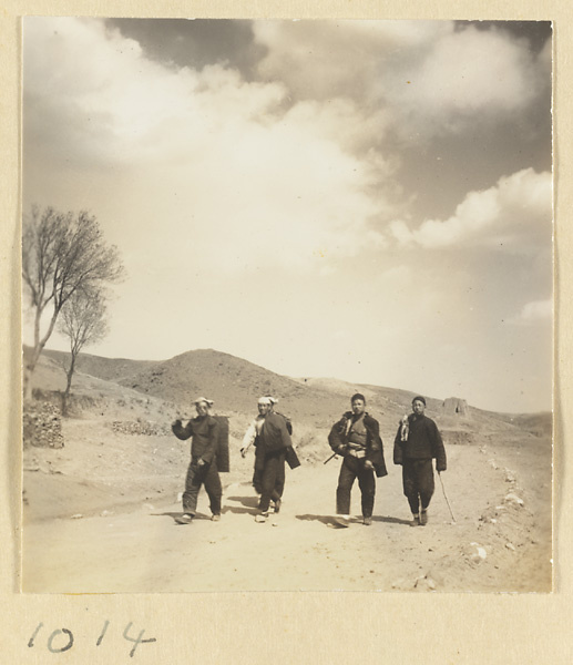 Four men walking on a road near the Yun'gang Caves